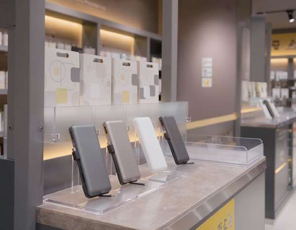 Illustrative convenience retail display with built-in-cable power banks in a modern store environment